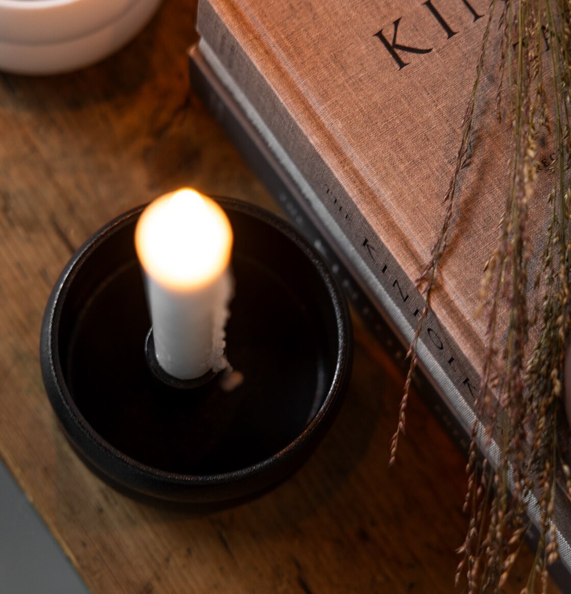 Ljusstake Svart Bolmen från Storefactory på träbord med bok