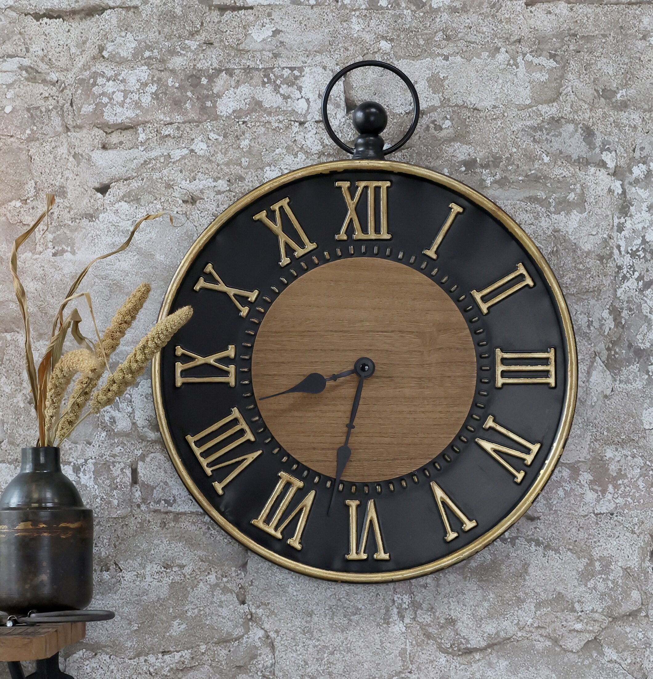 Väggklocka Svart/Guld från Chic Antique på rustik stenvägg