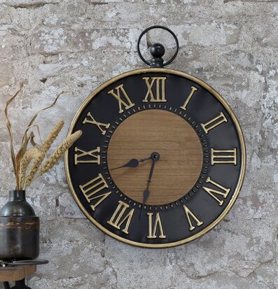Väggklocka Svart/Guld från Chic Antique på rustik stenvägg