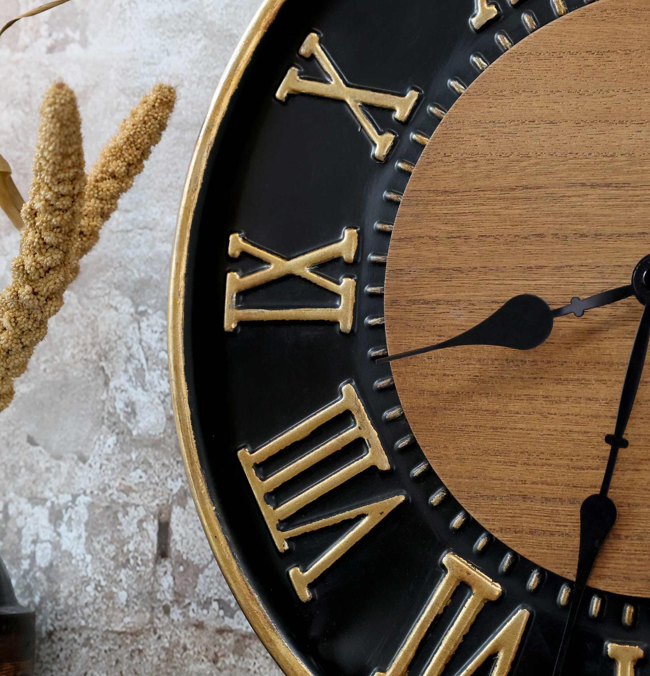 Väggklocka Svart/Guld från Chic Antique på grå stenvägg