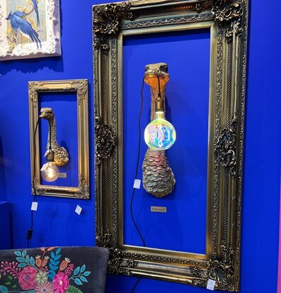 Ram Barock Guld från Werner Voss på blå vägg med lampa