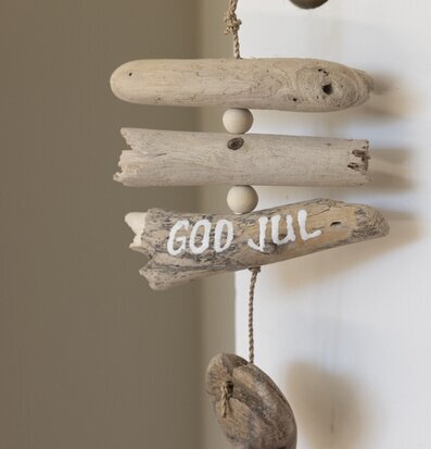 Mobil Drivved God Jul från Different Design mot vit vägg