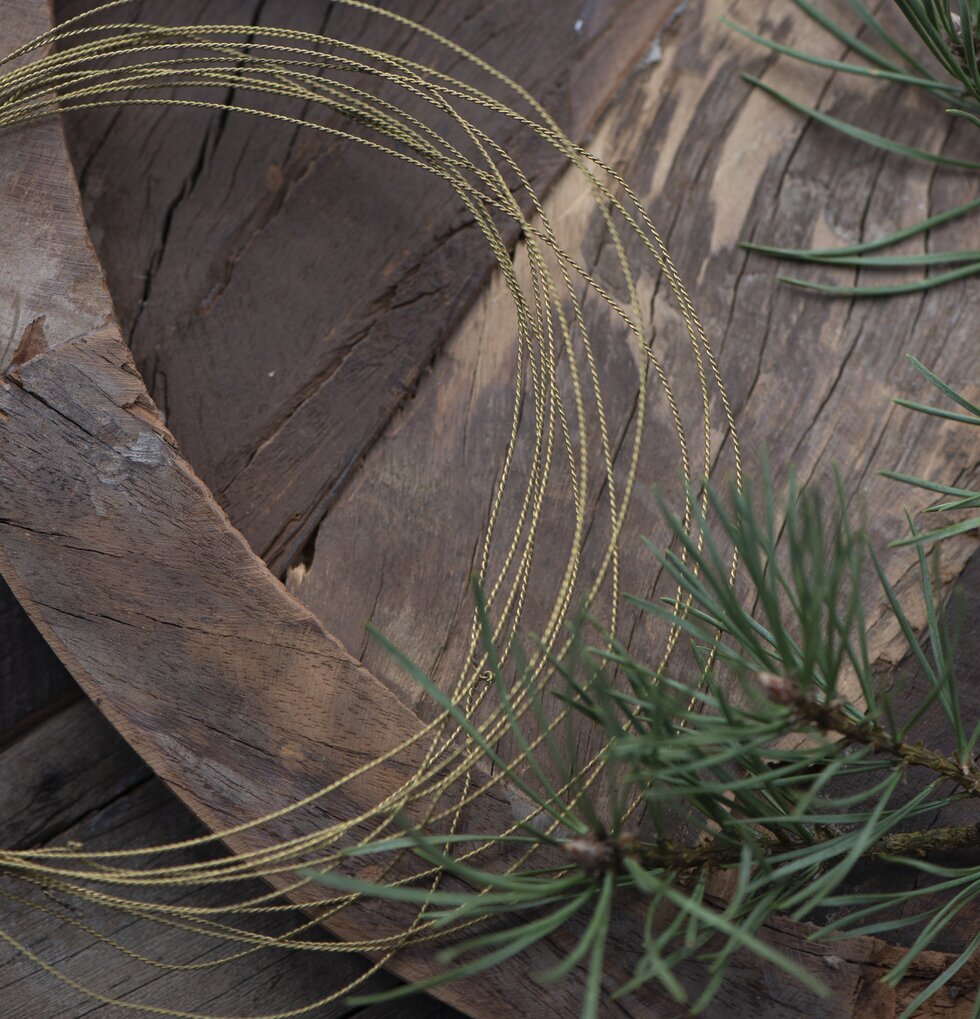 Metalltråd från IB Laursen på rustikt träbord med naturinslag