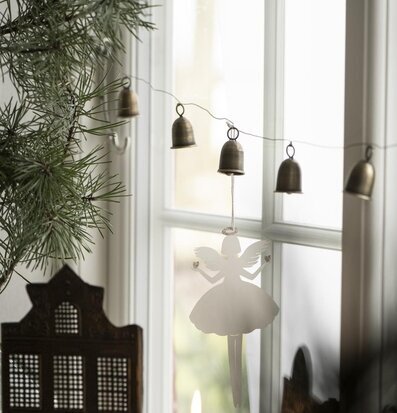 Girlang Klockor från IB Laursen i fönster med barrväxt