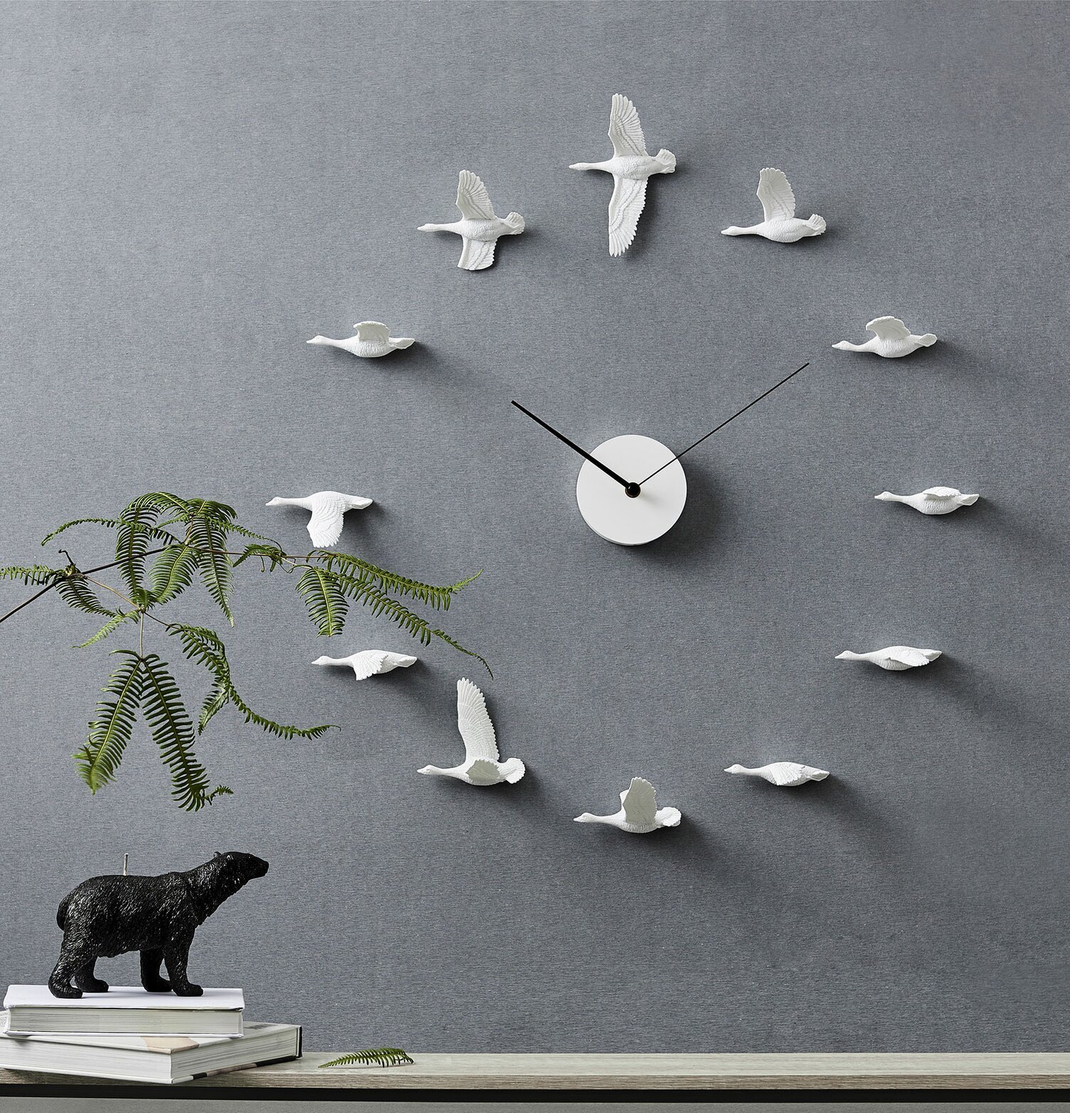 Väggklocka Migrantbird X Clock - Haoshi Design på grå vägg