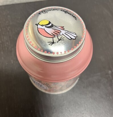 Bild av plåtburk med fågelillustration och rosa nyans