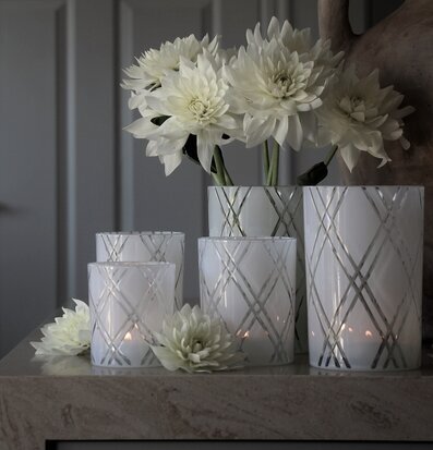 Foto av harmoniskt stilleben med ljuslyktor och blommor