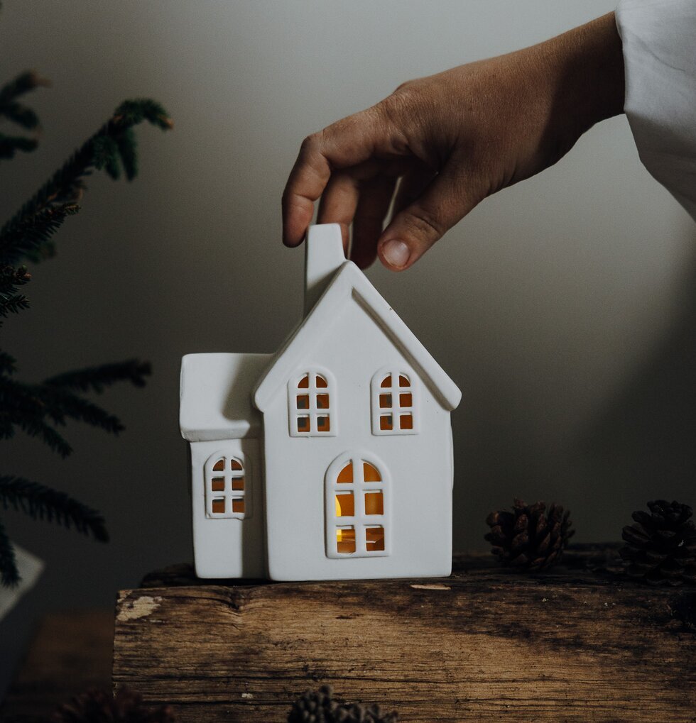 Ljusstake Hus Byn 4 från Storefactory på träyta med kottar