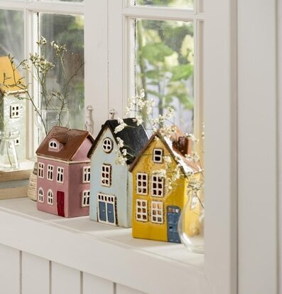 Foto av dekorativa ljuslyktor och böcker på fönsterbräda