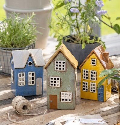 Bild av charmiga husformade ljuslyktor i trädgård