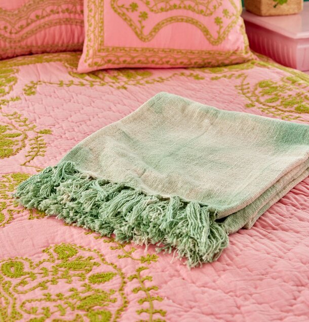 Bomullsfilt Batik Grön från Rice på rosa säng med gröna mönster