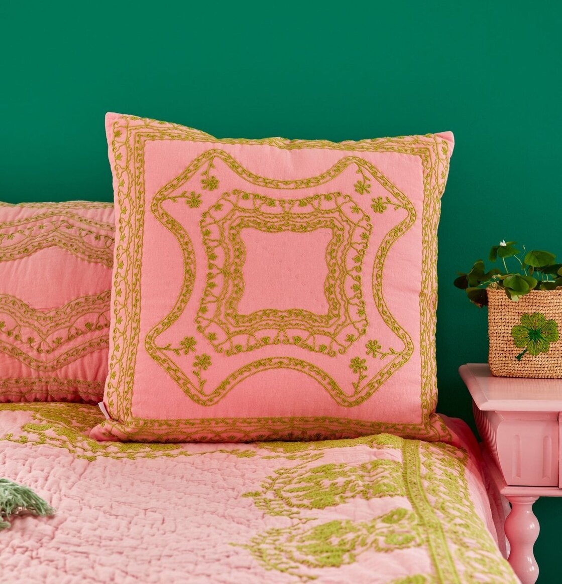 Prydnadskudde Rosa/Grön från Rice på quiltat täcke