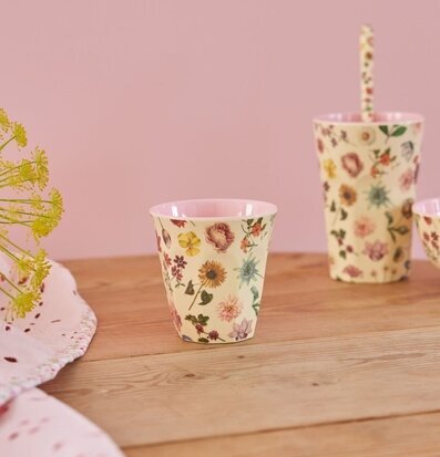 Bild av färgglad mugg med blommigt motiv på träbord