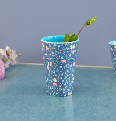 Foto av en mugg med fjärilar och blommor i fokus