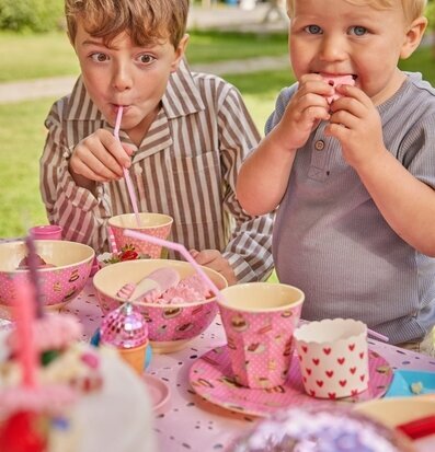 Foto av lekfull sommarscen med barn och färgglada muggar