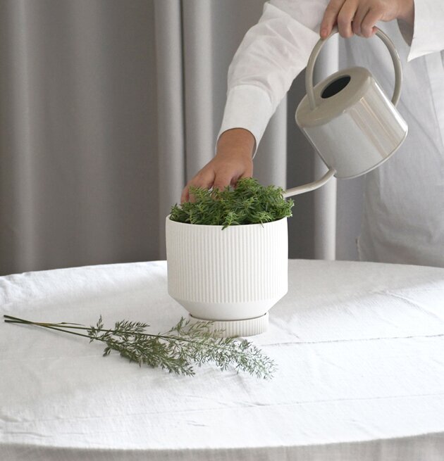 Person vattnar växt med Vattenkanna Beige från Storefactory