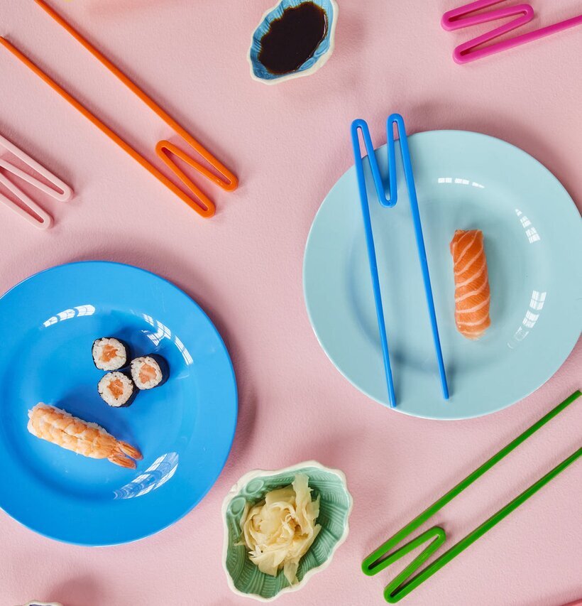 Ätpinnar Röd/Rosa från Rice på ett rosa bord med sushi