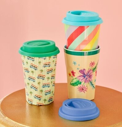 Bild av färgglada, mönstrade muggar på gyllene bord