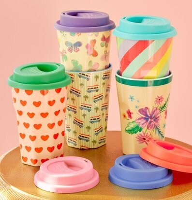 Foto av färgglada resmuggar med silikonlock på bord