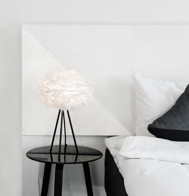 Eos Mini från Eos - Vita på svart sidobord i ljust sovrum