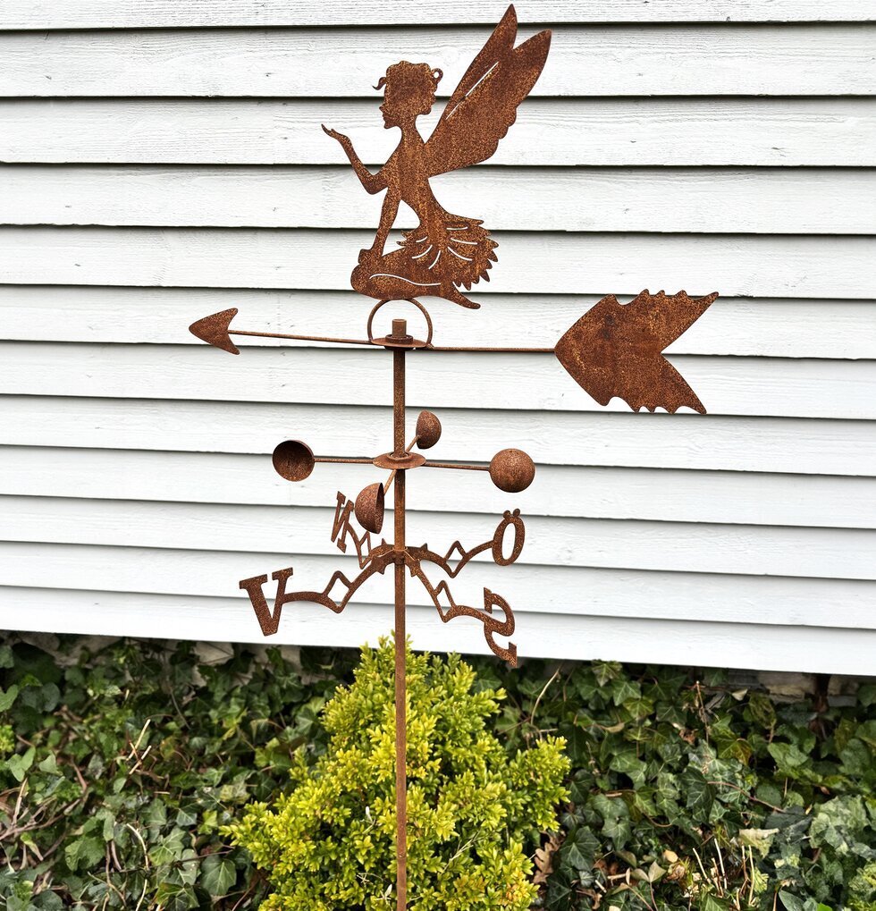 Vindflöjel Älva från Lind Decoration i en frodig trädgård