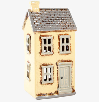 Bild av ljuslykta formad som ett hus i crèmefärg
