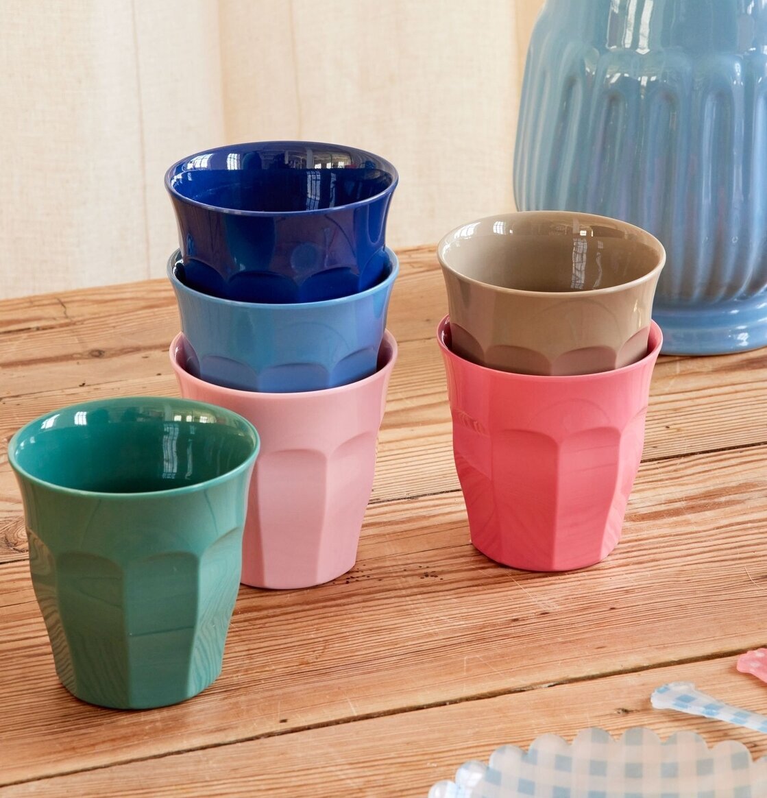 Foto av färgstarka muggar på träbord i hemtrevlig miljö