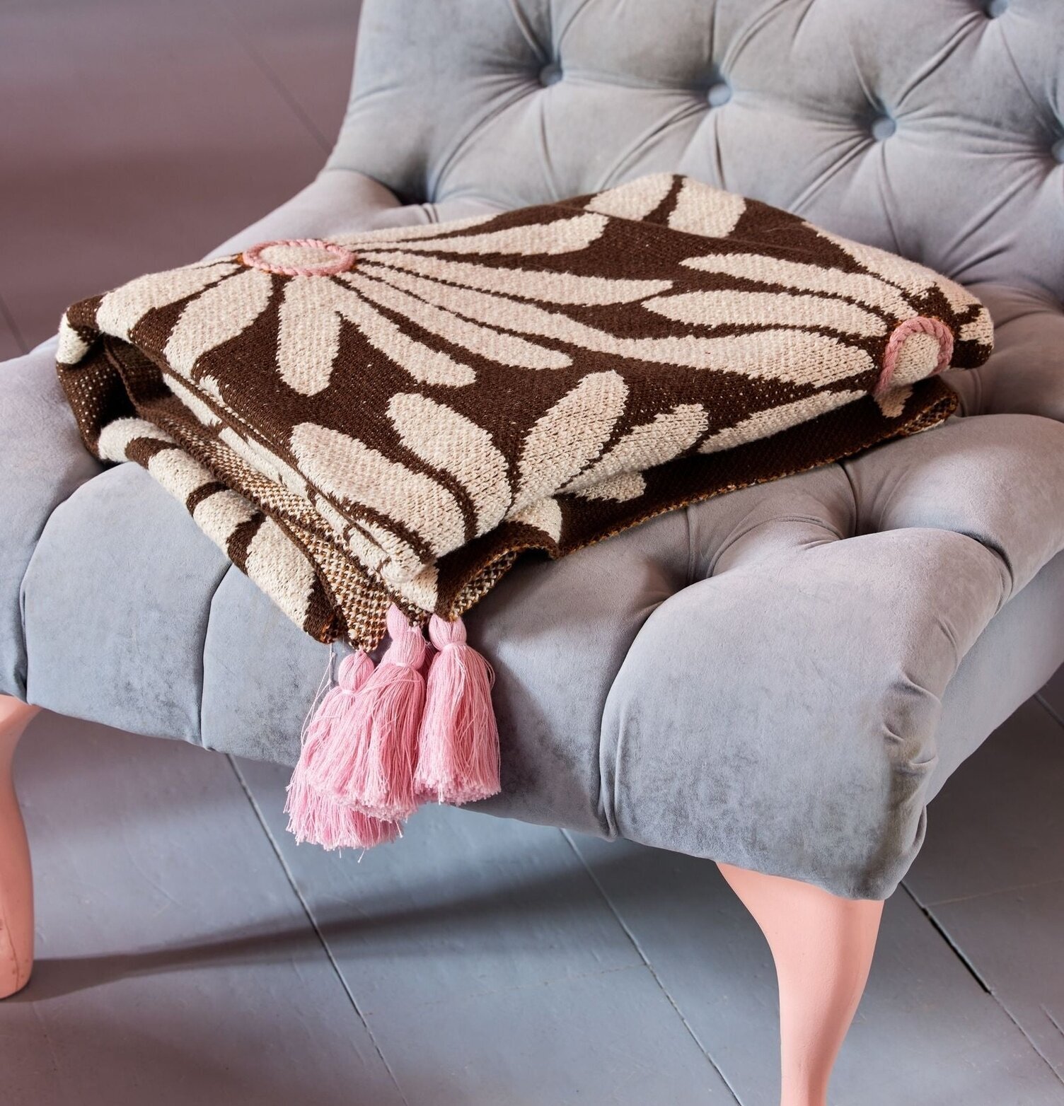 Bomullsfilt Brun från Rice på grå sammetsstol med tofsar