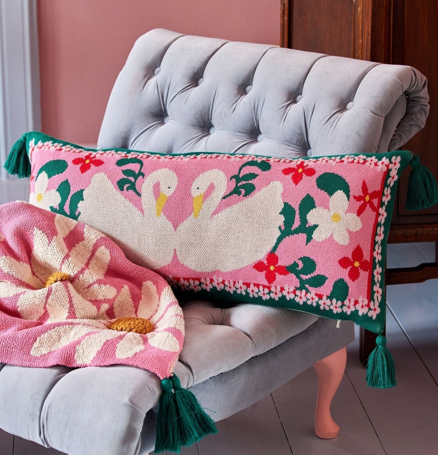 Prydnadskudde - Swan från Rice på ljusgrå fåtölj