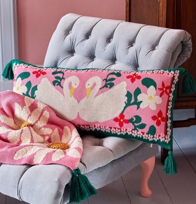 Prydnadskudde - Swan från Rice på ljusgrå fåtölj