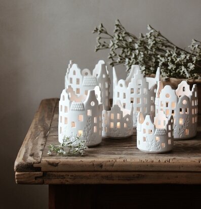 Bild av eleganta vita ljushus på rustik träyta