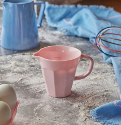 Mjölkkanna Melamin Rosa från Rice på en mjölig köksbänk