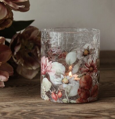 Bild av ljuslykta på rustikt träbord med blommotiv