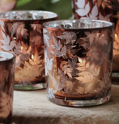 Bild av ljuslyktor med lövmönster och varm atmosfär