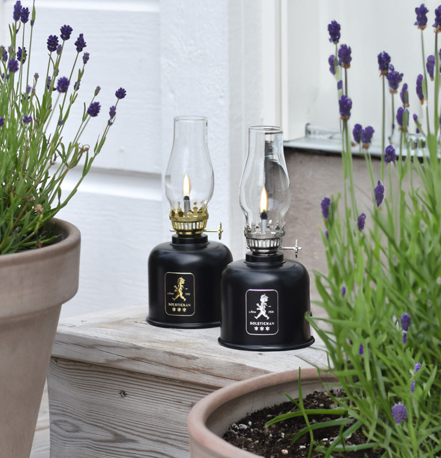 Fotogenlampa Svart/Guld från Solstickan i trädgårdsmiljö