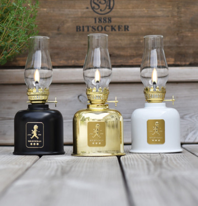 Fotogenlampa Svart/Guld från Solstickan på träplankor