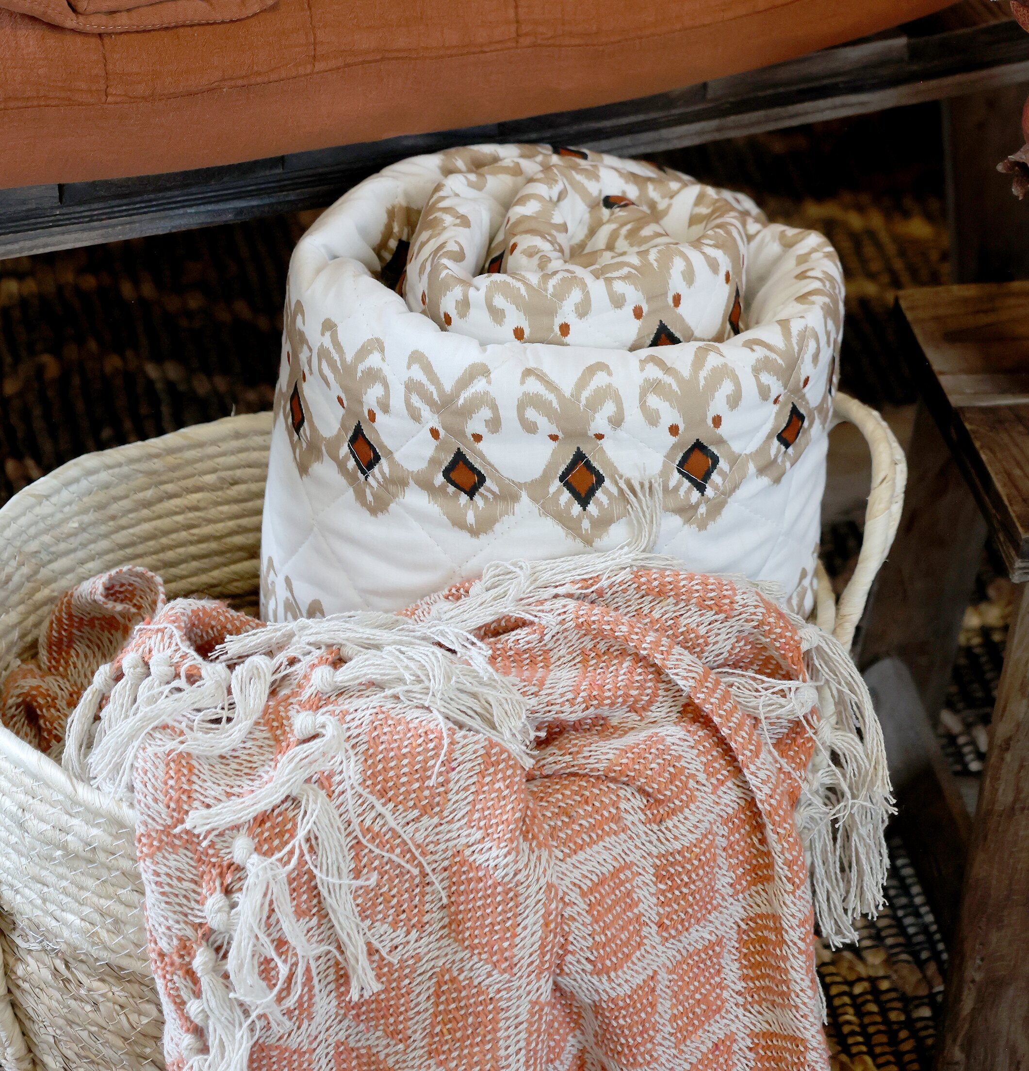 Pläd Terrakotta från Chic Antique i en korg med textilier