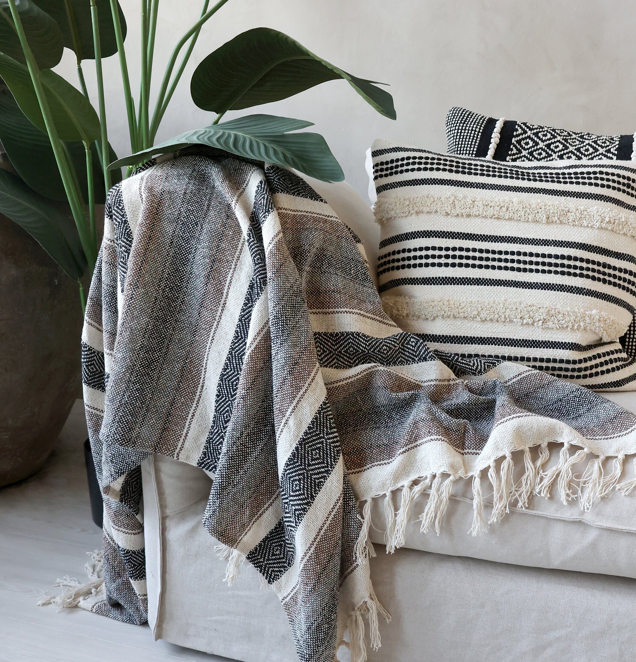 Aix Pläd Mocca/Svart från Chic Antique på neutral soffa