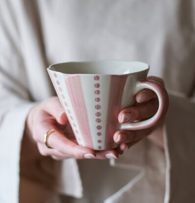 Keramikmugg Pink Awareness från Majas Cottage hålls av händer