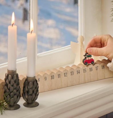 Julkalender 1-24 från IB Laursen på fönsterbräda med ljus
