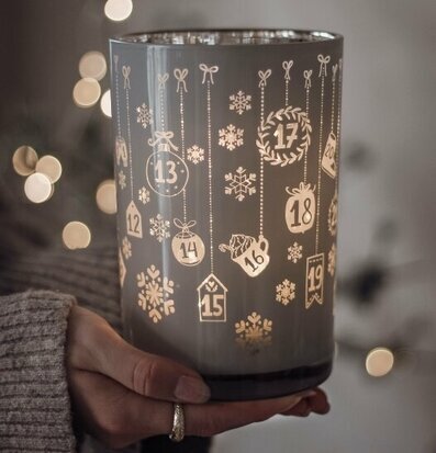 Bild av adventslykta med julmotiv och varmt ljussken