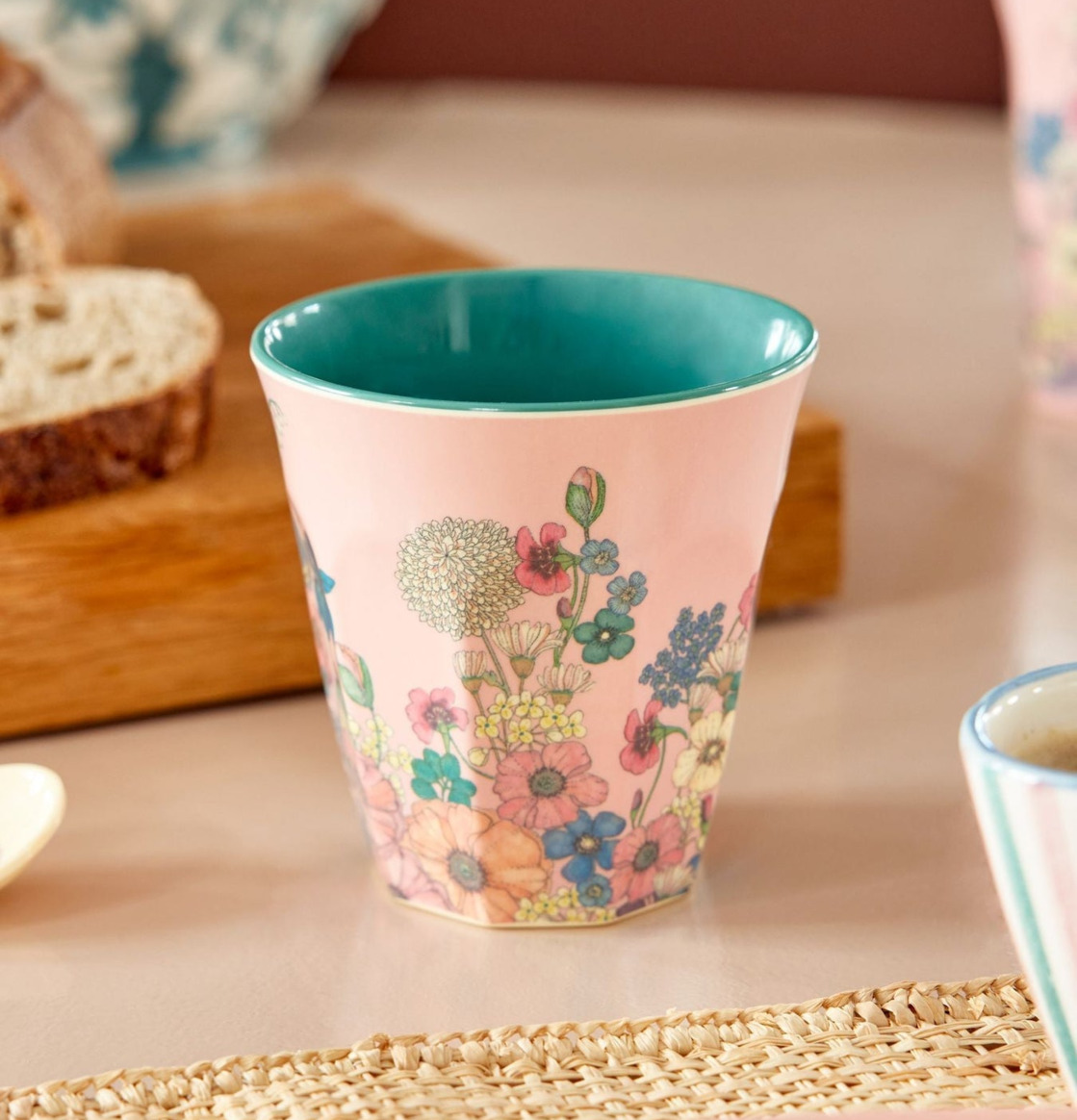 Bild av melaminmugg med blommönster och turkos insida