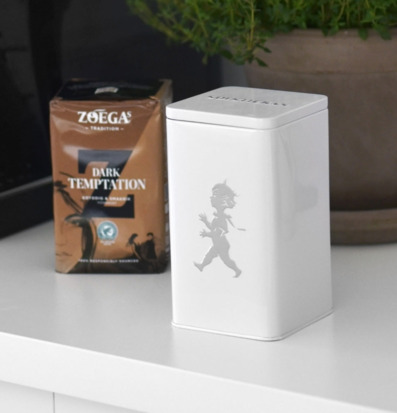 Bild av stilren kaffeburk och paket i modern miljö