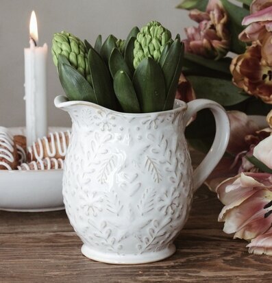 Bild av keramik, blommor och ljus i harmonisk miljö