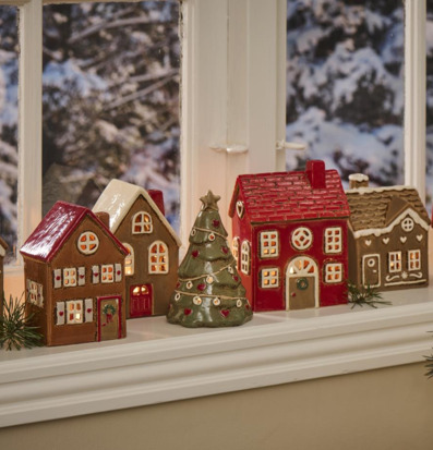 Foto av festlig fönsterbräda med keramikhus och gran