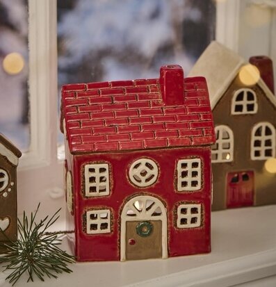 Bild av ljuslykta i form av ett rött hus på fönsterkarm