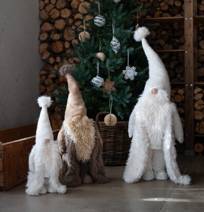 Foto av charmiga tomtenissar framför stämningsfull julgran