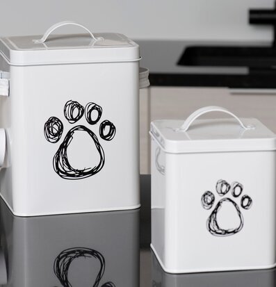 Bild på vita plåtburkar med tassavtryck och skopa