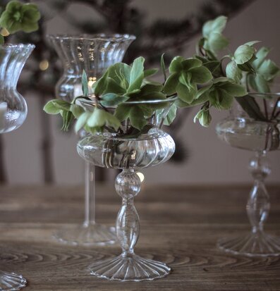 Bild av elegant glasvas med blommor på rustikt bord