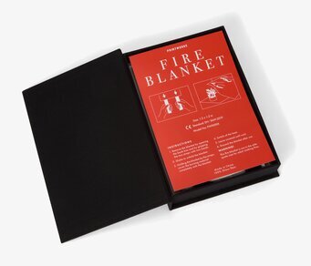 Bild av stilren brandfilt i svart med tydliga instruktioner